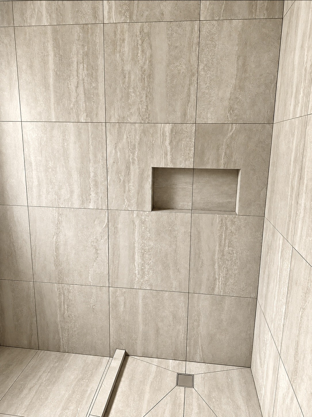 Close-up of beige stone-look tiling with a recessed shower niche